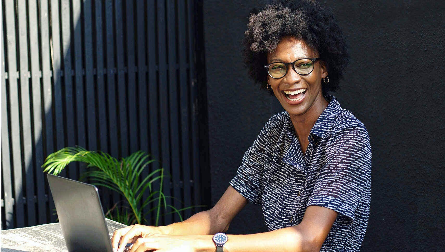 Akua smiling in front of a laptop